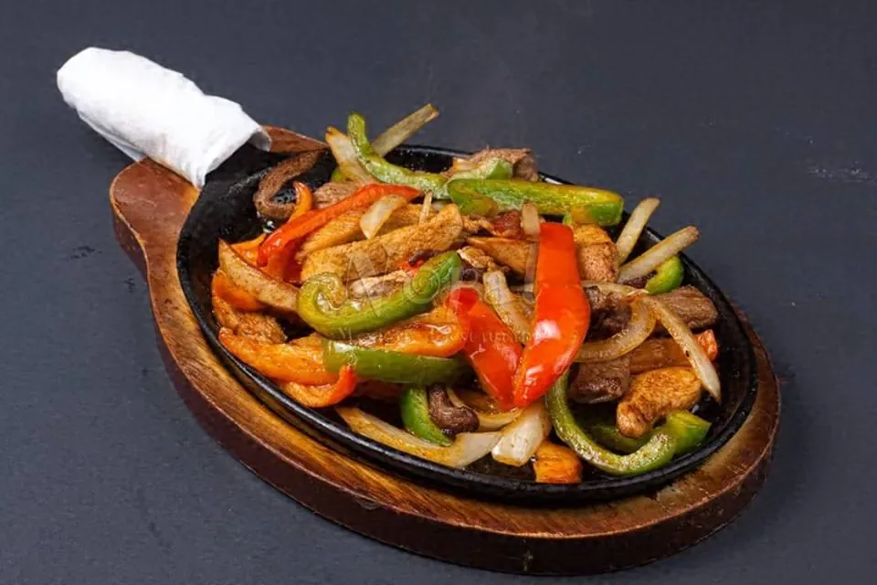 Fajitas con pimiento y cebolla en sartén caliente