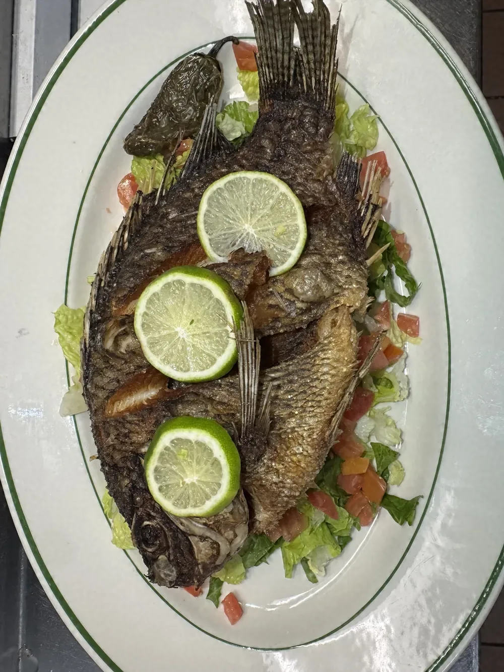 Pescado entero frito con rodajas de limón