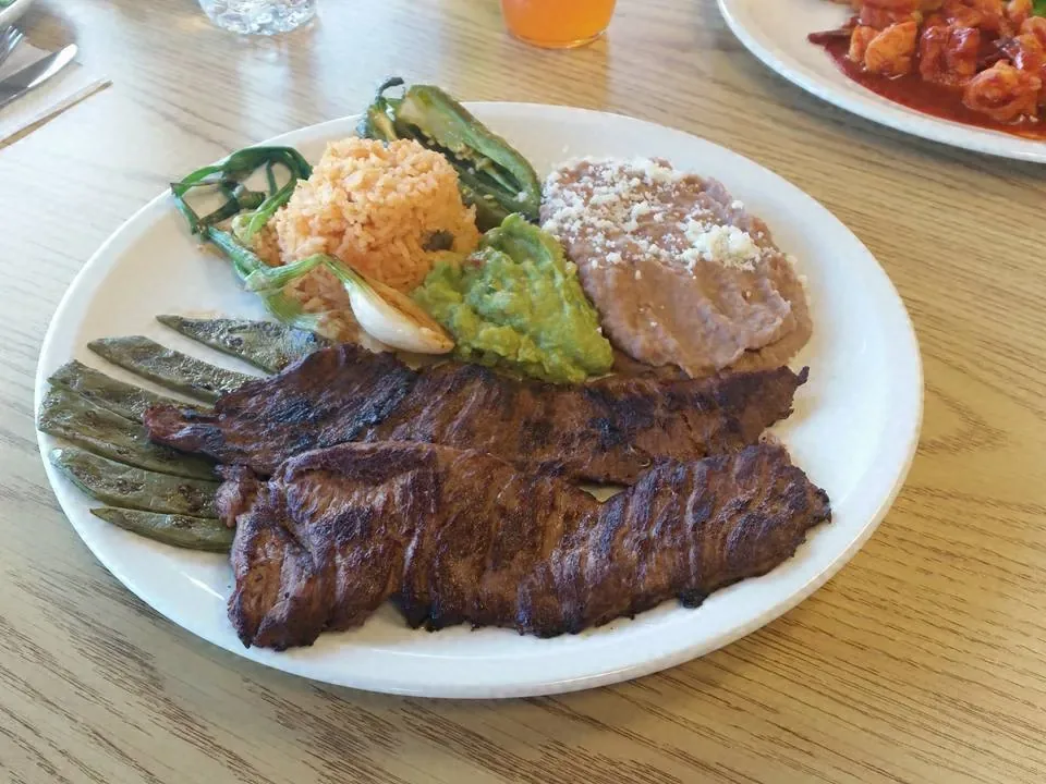 Carne a la parrilla con frijoles, arroz y guacamole
